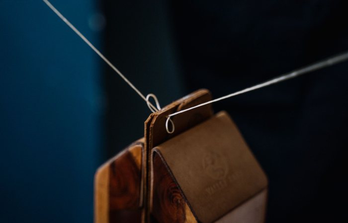 Detailed close-up of leather weights suspended on a wire, showcasing craftsmanship and material texture.