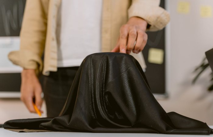 Close-up of a hand pulling a black cloth, showcasing a mysterious setup.