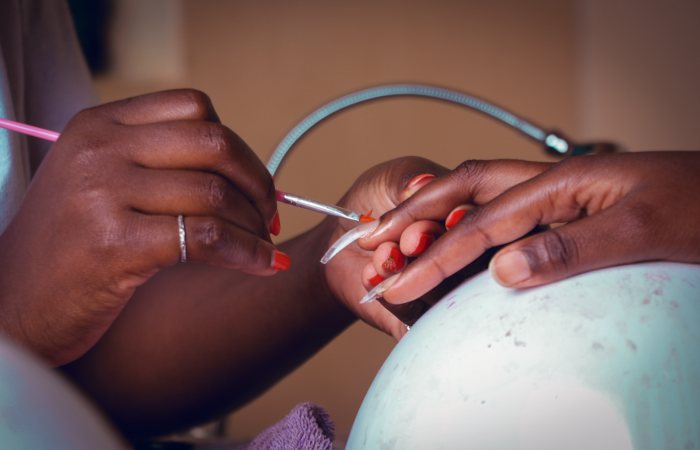 Detailed view of a nail technician applying polish during a manicure session.